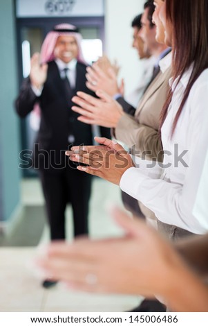 business team applauding to welcome arabian businessman