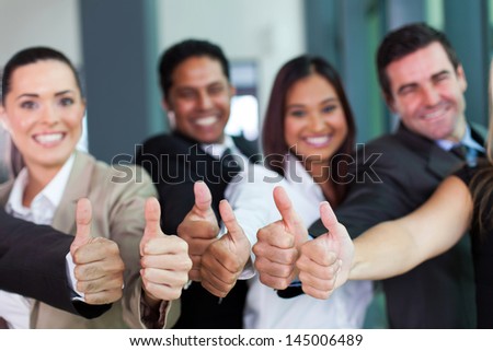 cheerful business group giving thumbs up