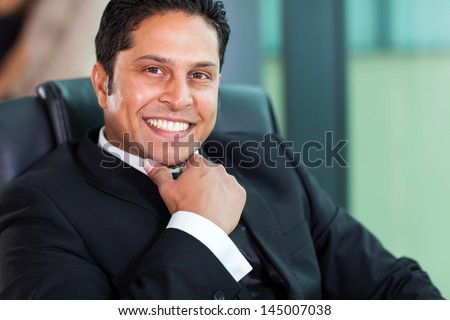 handsome indian corporate worker sitting in office