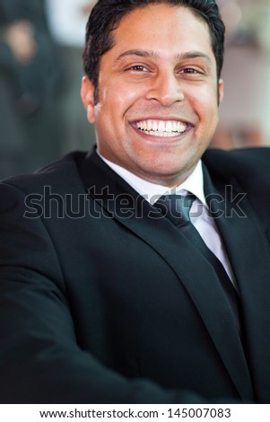 portrait of happy indian businessman in black suit