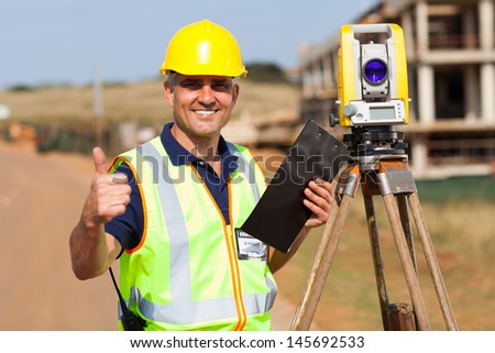 senior surveyor giving thumb up on construction site