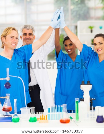successful team of scientists high five in lab