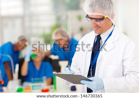 smart senior scientist writing medical report in the lab