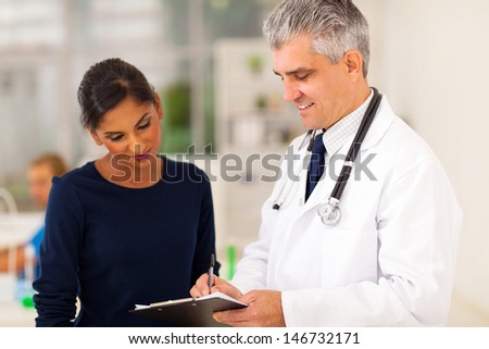 senior doctor checking young patient\'s test result