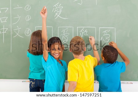 happy schoolgirl after writing chinese on blackboard
