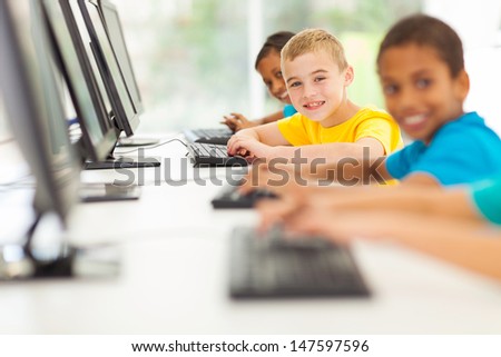 group of happy elementary school students in computer room