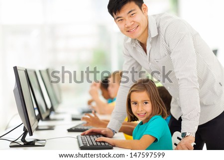 portrait of elementary school computer teacher and students in computer room
