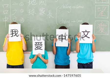 group of primary school students holding paper saying i love chinese