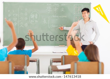 smiling educator teaching chinese language to group of primary kids