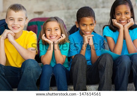 Cheerful Primary School Children Sitting Outdoors