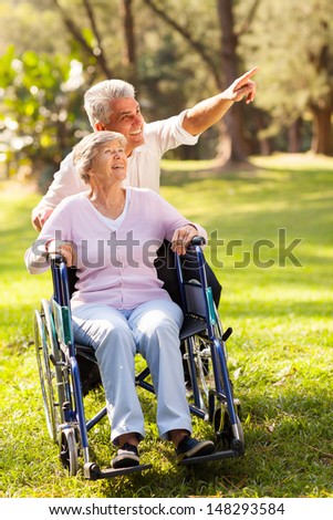 caring mid age son taking senior mother for a walk