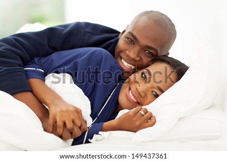 lovely african american couple sleeping in bed