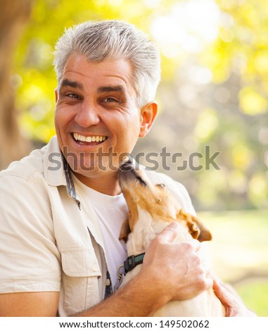 happy middle aged man and pet dog outdoors