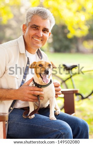 smiling mature man and pet dog outdoors