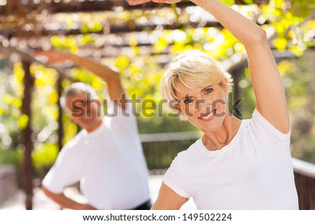 active senior woman exercising with husband outdoors