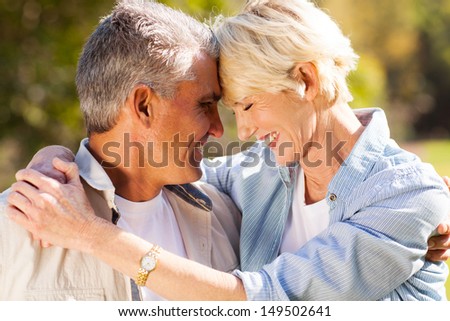 loving middle aged couple hugging with eyes closed closeup portrait