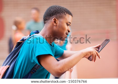 cute male african college student using tablet computer