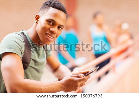 portrait of cute african college student with tablet computer on campus