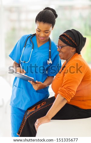 Beautiful Young African Nurse Explaining Medical Test Result To Senior Patient