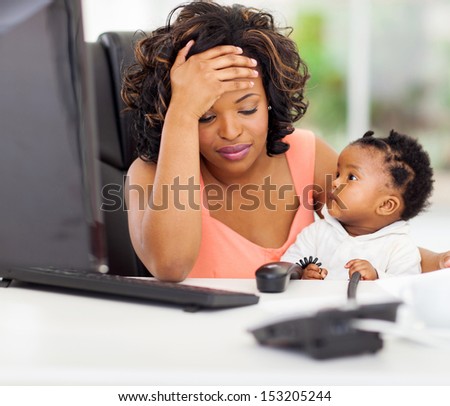 frustrated african american businesswoman with her little baby in office