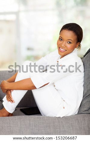 beautiful young black woman relaxing on a couch at home
