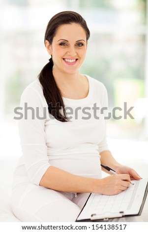 beautiful pregnant woman with clipboard planning pregnancy