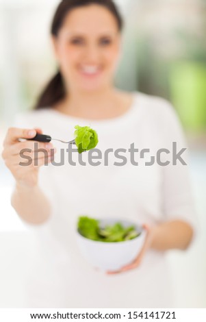 close up of woman giving fresh green salad
