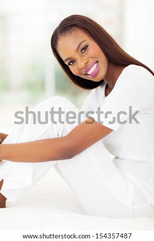 portrait of pretty african woman sitting on bed