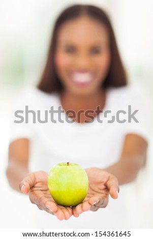 close up portrait of african american woman holding a apple with both hands