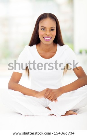 beautiful young african american woman sitting on bed