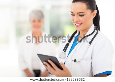 beautiful female healthcare worker using tablet computer in hospital