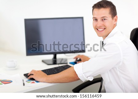 good looking businessman working on a computer in office