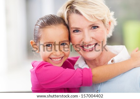 beautiful young girl hugging her senior grandmother