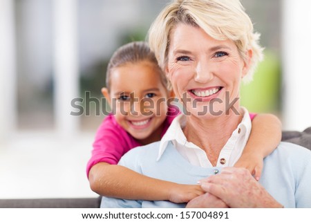 happy little granddaughter and senior grandmother at home