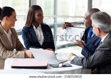 african businessman explaining sales graph to colleagues in meeting