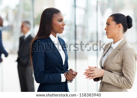 Successful Female Colleagues Having Conversation In Office