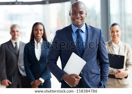 Handsome African Businessman With Group Of Businesspeople On Background