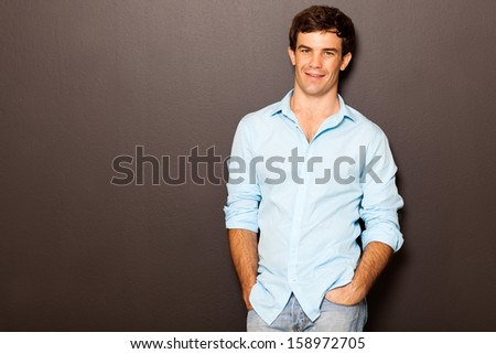handsome man posing with hands in pockets on black