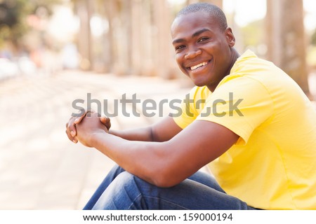 handsome african american guy sitting in urban city