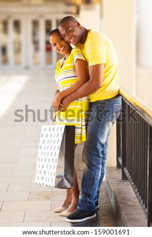 beautiful afro american couple hugging at shopping mall
