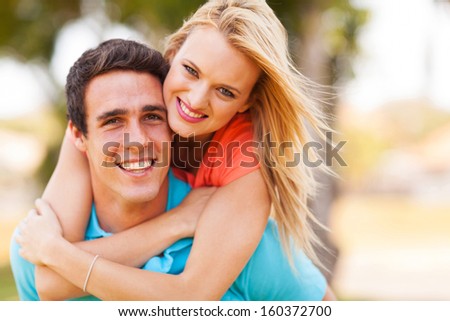 attractive young couple piggybacking outdoors