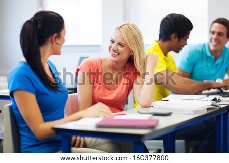 cheerful university students chatting in lecture hall