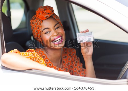 cheerful african woman showing a driving license she just got