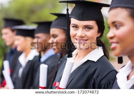 smiling female college graduate standing with friends at graduation