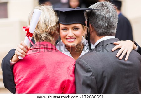 gorgeous university female graduate hugging her parents after graduation