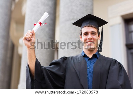happy male university student holding his graduation certificate