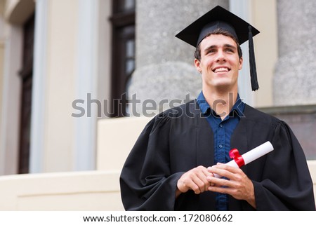 cheerful male graduate outside college building