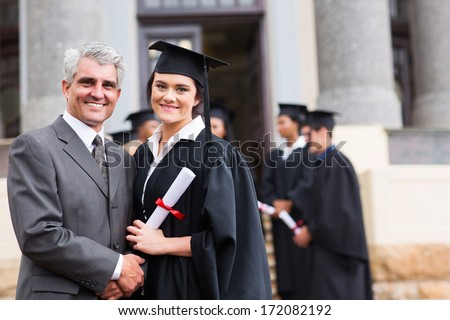 pretty female graduate with her father at university graduation