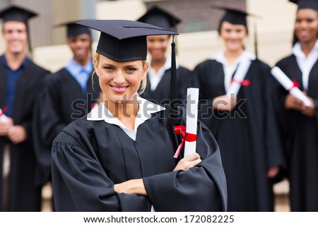 beautiful female college graduate with arms crossed at ceremony