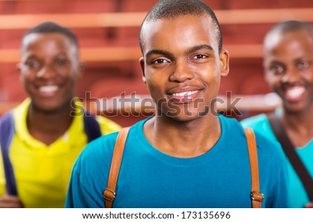 handsome african american college boy with friends on background